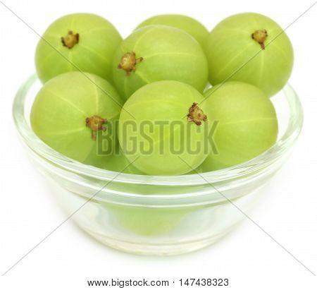 Amla fruits in a glass bowl over white background