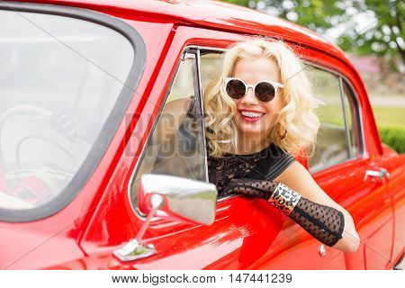Happy woman leaning out of the car's window