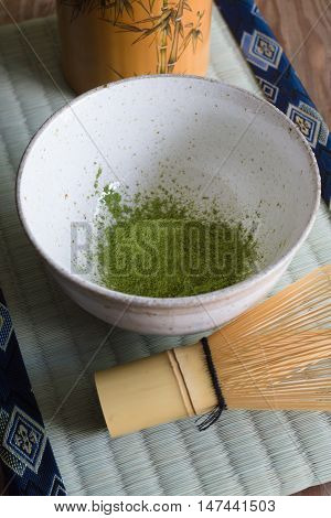Japanese Matcha green tea powder in a chawan or traditional ceramic bowl with a chasen or bamboo whisk