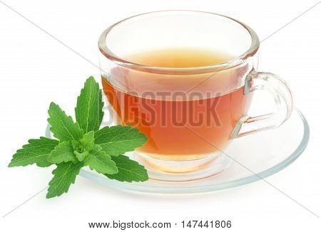 Herbal tea in a cup with stevia leaves over white background