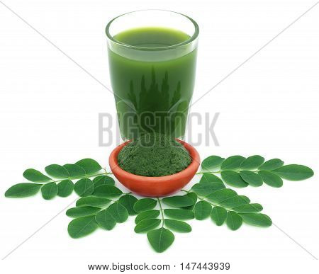 Edible moringa leaves with ground paste over white background