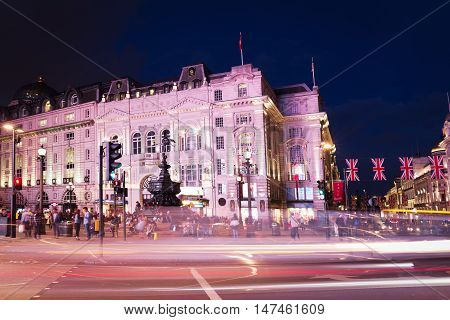 Popular Tourist Picadilly Circus With Flags Union Jack In Night