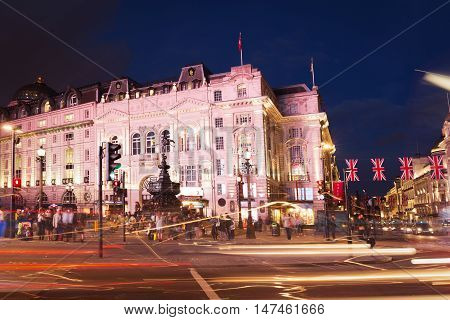 Popular Tourist Picadilly Circus With Flags Union Jack In Night
