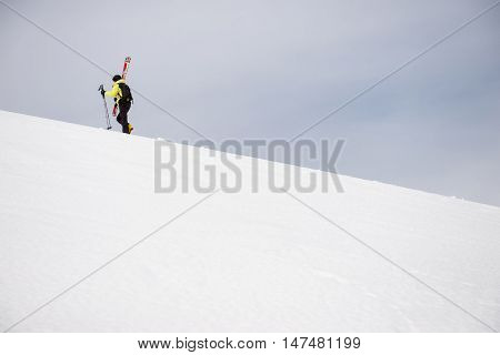 Skiier climbing to the top of the mountain.