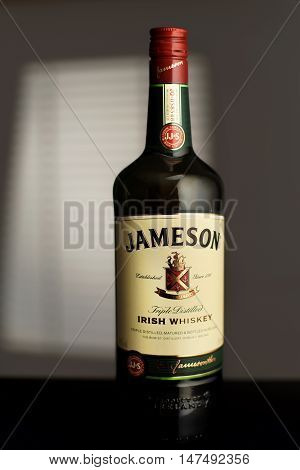 MINSK, BELARUS-AUGUST 25, 2016.  Jameson is a blended Irish whiskey produced by the Irish Distillers subsidiary of Pernod Ricard. A bottle Jameson in the room illuminated by the light from the window