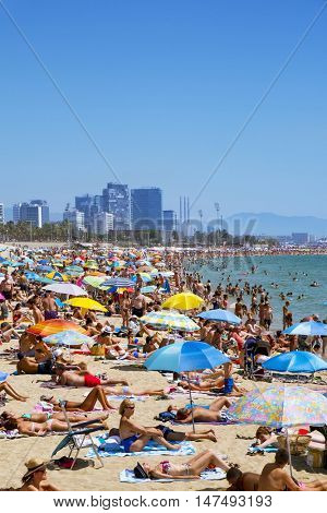 BARCELONA, SPAIN - JULY 10: People sunbathing at Platja del Bogatell beach on July 10, 2016 in Barcelona, Spain. This busy beach is mainly frequented by the locals