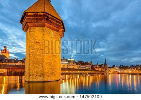 Night view towards Chapel Bridge (Kapellbruecke) together with the octagonal tall tower (Wasserturm) it is one of the Lucerne's most famous tourists attraction