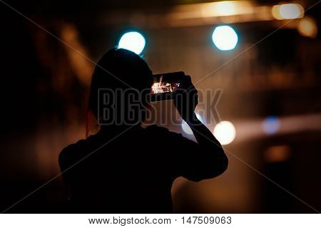 People makes photo with His smartphone on rock concert to share the moment with friends on social networks