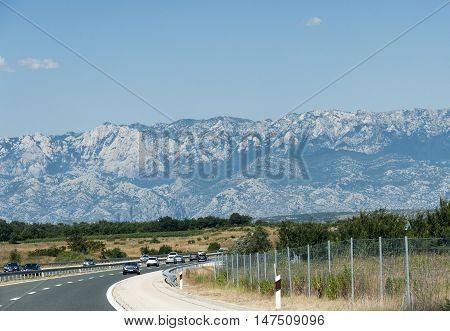Highway in Croatia main route from central Europe to sea in summer with mountains in background.