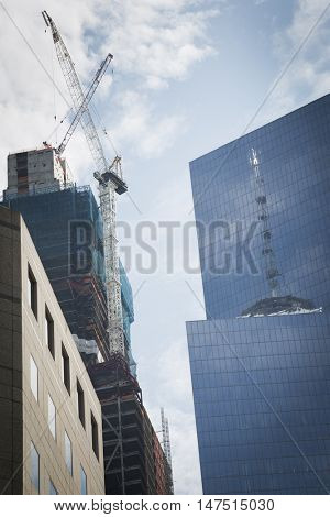 NEW YORK - SEPT 9 2016: Reflection of the Freedom Tower on the glass of Tower 4 at World Trade Center site and Tower 3 under construction the weekend of the 15th anniversary of the terrorist attacks.