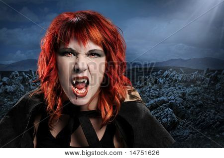 Mulher vampiro sibilando sobre uma paisagem de noite