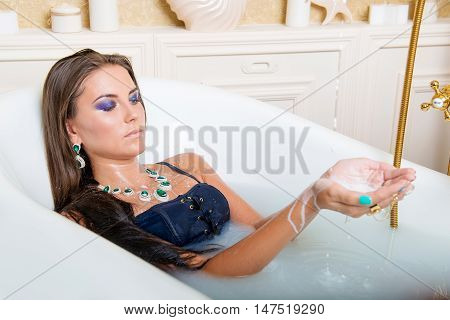 Beautiful girl with long hair lying in milk bath