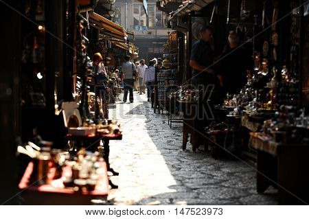 BOSNIA SARAJEVO - AUGUST 27 2015: Tourists looking at souvenirs in old Sarajevo bazaar on August 27 2015 in Sarajevo.