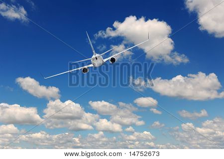 Airliner flying over blue sky with clouds