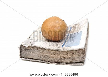 An old book with a rotten orange