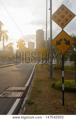 a city street at dusk with light trails and traffic sign