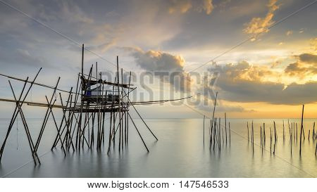 Image of traditional fishermen timber and bamboo jetty known as LANGGAI during sunset