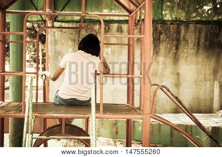 cute asian girl sitting alone at playground