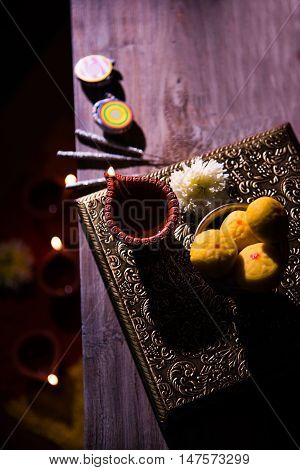 beautiful diwali diya with fire crackers and sweet pera, selective focus