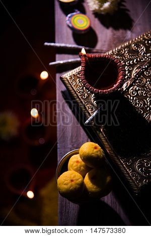 beautiful diwali diya with fire crackers and sweet pera, selective focus