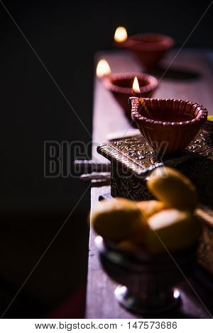 beautiful diwali diya with fire crackers and sweet pera, selective focus