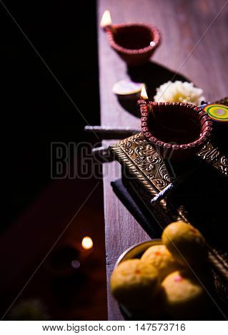 beautiful diwali diya with fire crackers and sweet pera, selective focus
