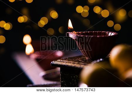 beautiful diwali diya with fire crackers and sweet pera, selective focus