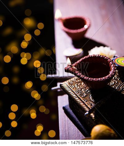beautiful diwali diya with fire crackers and sweet pera, selective focus
