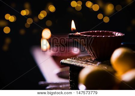 beautiful diwali diya with fire crackers and sweet pera, selective focus
