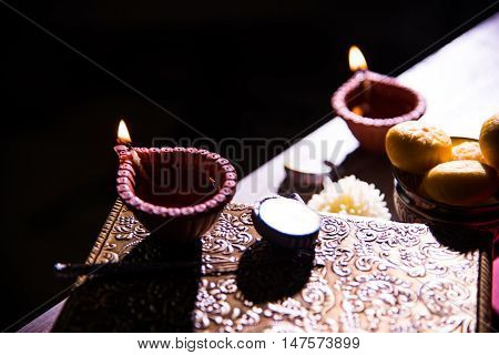 beautiful diwali diya with fire crackers and sweet pera, selective focus