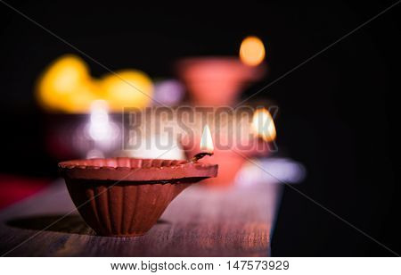 beautiful diwali diya with fire crackers and sweet pera, selective focus
