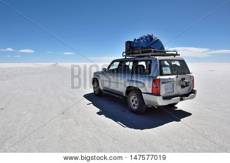 SALAR DE UYUNI - AUGUST 28: Off-road car on surface of lake Salar de Uyuni in Bolivia on August 28 2016. Salar de Uyuni is the worlds largest salt flat at 10582 square kilometers