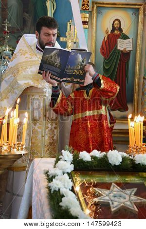 VOYUTYN UKRAINE - JANUARY 08: Orthodox priest and little sextons during holiday prayers in Voyutyn on January 08 2009.