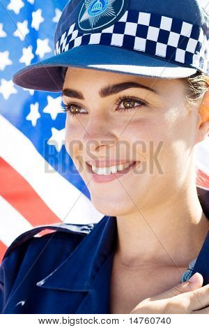usměvavý americký ženský policejní důstojník portrét, pozadí je americká vlajka
