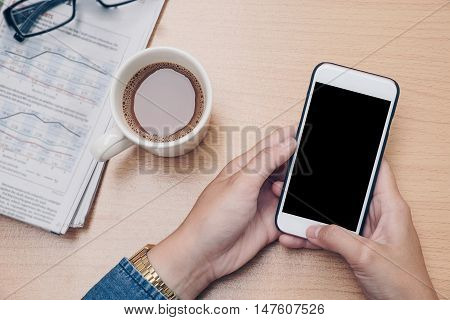 hand using Mobile phone on old wood background