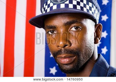 Africký Americký policista portrét, pozadí je vlajka USA
