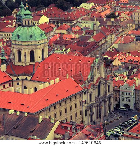 Panorama of Prague Old Town with red roofs and St. Nicholas Church in the quarter of Mala Strana Czech Republic. square vintage toned image