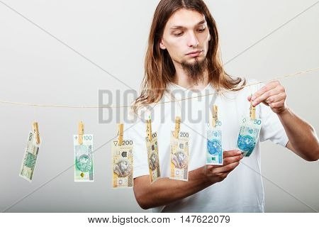 Riches and fortune. Young happy man with a lot of money on grey background. Winning the lottery concept.