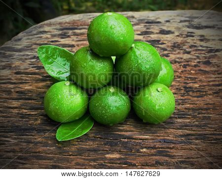 lemon with green leafs on wood background