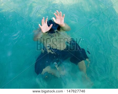 Drowning man in sea asking for help with raised his arms. Safety concept.
