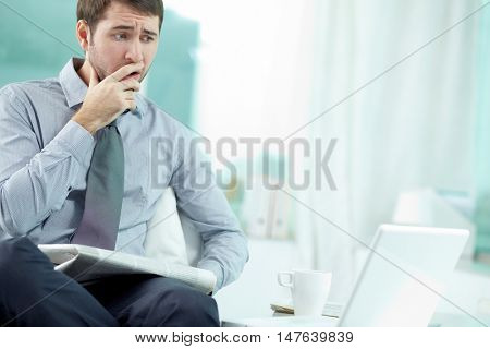 Businessman sitting at his office and getting bad news