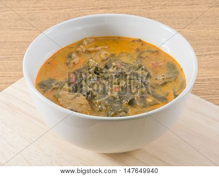 Thai Cuisine and Food Delicious Thai Spicy Creamy Coconut Milk Curry with Cassia Leaves and Grilled Beef Fillet.