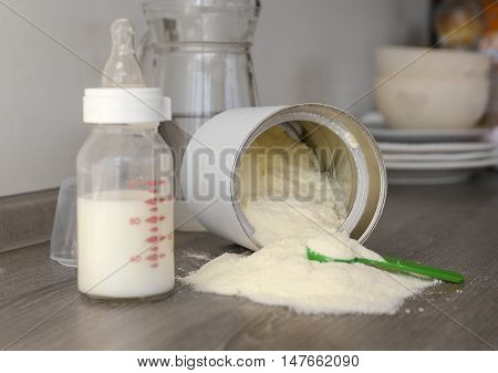 Feeding bottle with baby milk formula on table