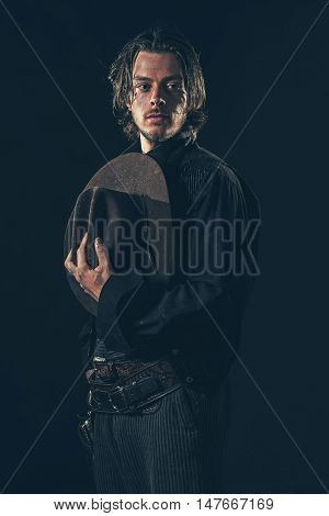 Vintage Cowboy Holding Hat In Hand. Young Man. Studio Shot.