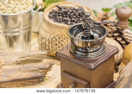 Coffee beans and coffee grinder and cup of coffee on wooden table