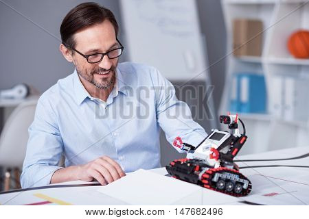 Happy as a kid. White man in glasses trying new electronic device.