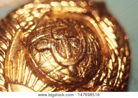 Soviet symbols hammer and sickle. In the old metal badge in gold.
