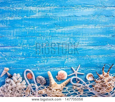 Seashells with fishing net on blue wooden background