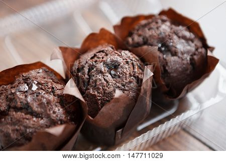 Three Chocolate Muffins In Plastic Container