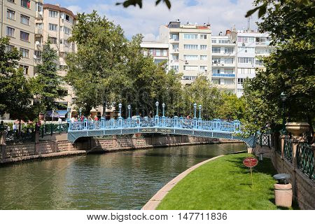 ESKISEHIR TURKEY - SEPTEMBER 03 2016: People passing over the bridge on Porsuk River. Porsuk river is one of the most populer touristy place with boat tours and entertainment in Eskisehir.